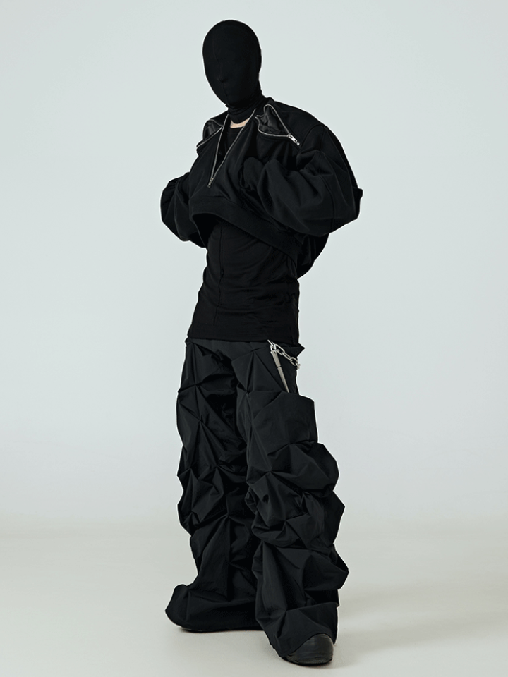This anti-fashion uneven hem black coat features irregular raw hemline and minimalist dark silhouette, expressing rebellious deconstructed alternative aesthetics.