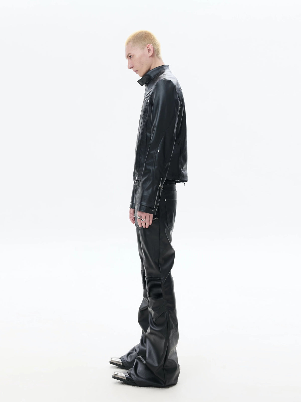 Black denim pants accented with bold industrial hardware, blending rugged utilitarian detail into dark alternative street styling.