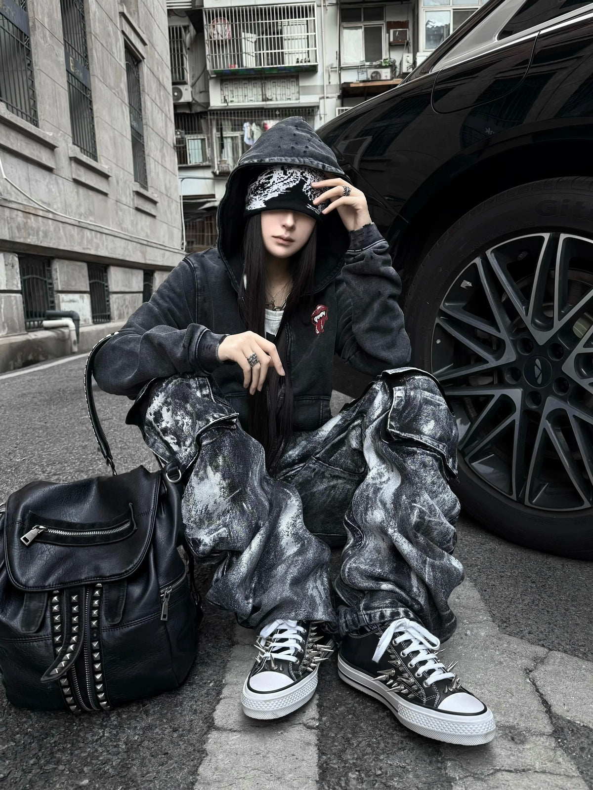 This underground-style faded black outerwear boasts worn-in tones and a moody silhouette for alternative street aesthetics.